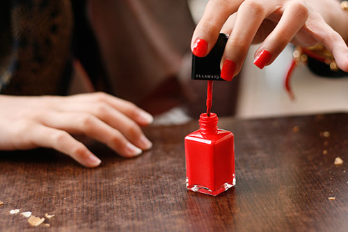 Red nail polish in application 3a0fa
